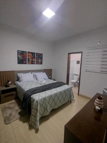 a bedroom with a large bed and a bathroom at Apê aconchegante in Franca