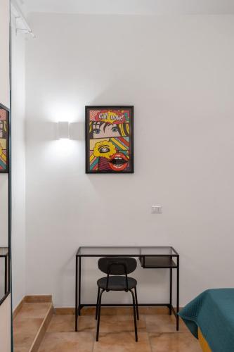 a table and a chair in a room at Pangea Stabia Rooms in Castellammare di Stabia