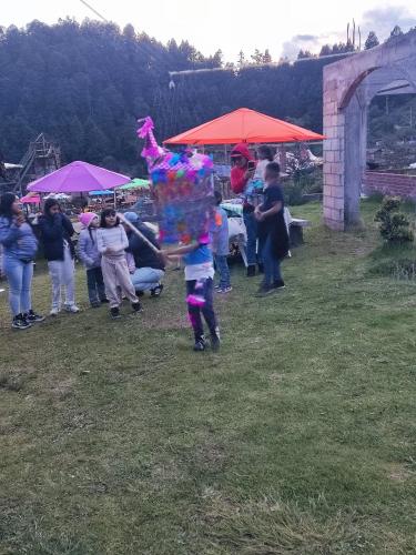 a group of people standing in a field with a person holding a kite at Palapas los Axolotes, Valle del Potrero, la Marquesa in San Pedro Atlapulco