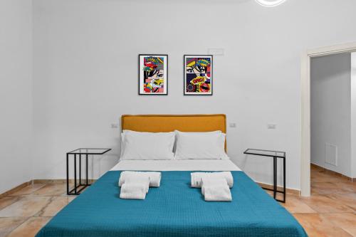 a bedroom with a blue bed with two pillows at Pangea Stabia Rooms in Castellammare di Stabia