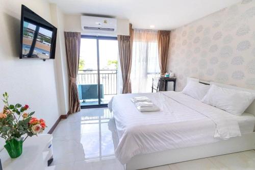 a bedroom with a large white bed and a balcony at Arunsakhon luxury condo in Ban Khok Kham