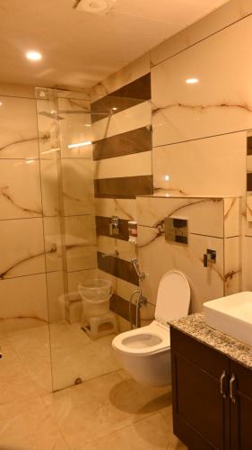a bathroom with a toilet and a sink at Hotel Saffron kiran By Aamod Suites in Dalhousie