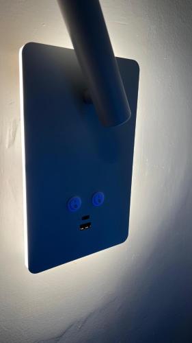 a lightswitch with a blue face on a wall at T Cozy Chalet in Ash Shāghūr