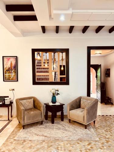 a living room with two chairs and a table at Maison d'Hôte Angele in Sfiani