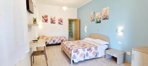 a hotel room with a bed and a desk and a bed at Hotel Arenauta in Gaeta