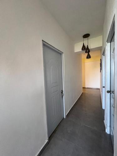 an empty hallway with a white door and a tile floor at Habitaciones La familia in Santa Bárbara de Samaná