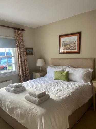 ein Schlafzimmer mit einem weißen Bett mit Handtüchern darauf in der Unterkunft Fordie East Cottage in Comrie