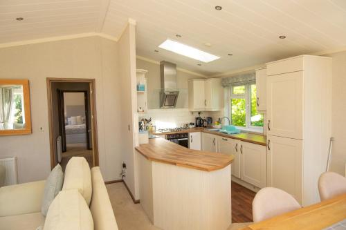 a kitchen with white cabinets and a counter top at Welhams Meadow Holiday Lodges in Ringshall