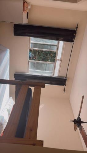 a window in a room with a wooden ladder at hotel laren in Sete Lagoas