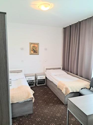 a room with two beds and a table and a chair at Hotel Sezam Kraczkowa Smart Lock in Kraczkowa