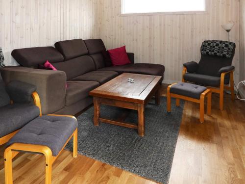 a living room with a couch and a table and chairs at 4 star holiday home in Storvorde in Storvorde