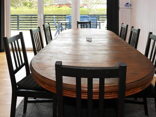 a dining room table with chairs and a large wooden table at 4 star holiday home in Storvorde in Storvorde