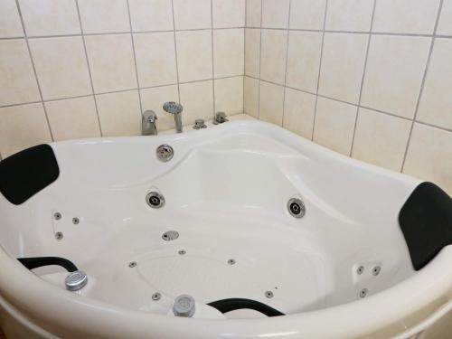 a white bath tub in a bathroom with tiles at 4 star holiday home in Storvorde in Storvorde