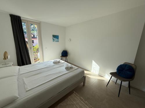 a white bedroom with a bed and a window at Schloss Locarno - Self Check-In in Locarno