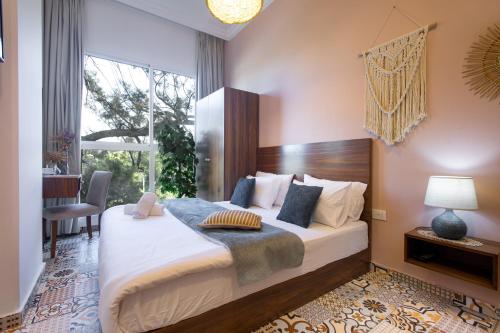 a bedroom with a large bed and a window at Mar Mikhael Studios in Beirut