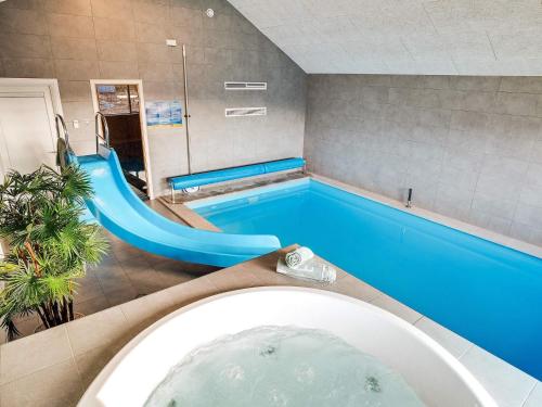 a bathroom with a tub and a swimming pool at 5 star holiday home in Ringkøbing in Ringkøbing