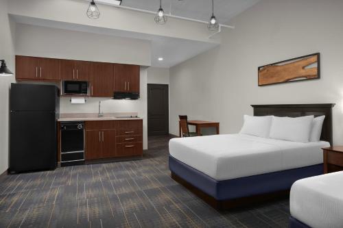 a hotel room with a bed and a kitchen at The Suites Hotel at Waterfront Plaza in Duluth