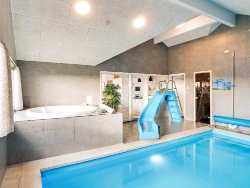 a large bathroom with a swimming pool and a slide at 5 star holiday home in Ringkøbing in Ringkøbing