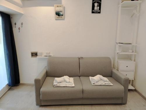 a couch in a living room with two towels at La Casa dei Laghi 1 Comabbio Monate Maggiore Orta in Mercallo