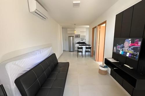 1 dormitorio con sofá y TV en una habitación en Vista Atlântica Pajuçara AP401, en Maceió