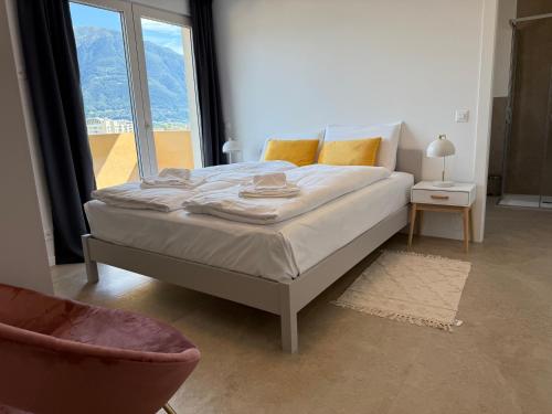 a bedroom with a bed with a large window at Schloss Locarno - Self Check-In in Locarno
