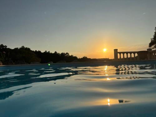 a pool with the sunset in the background at Chateau De La Ricardie Beautiful Rural Property Gite Villa in Liorac