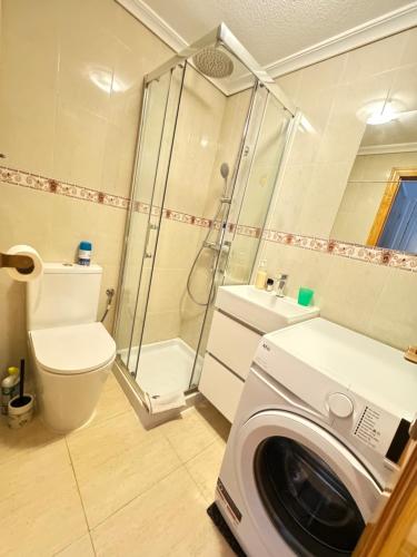 a bathroom with a washing machine and a washer at ADA & Gran Alacant & Vacation in Gran Alacant