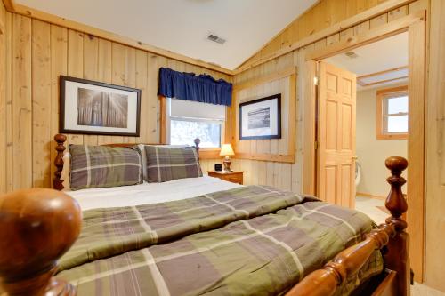 ミノクアにあるMinocqua Lakefront Cabin with Deckの木製の壁の部屋にあるベッドのある寝室