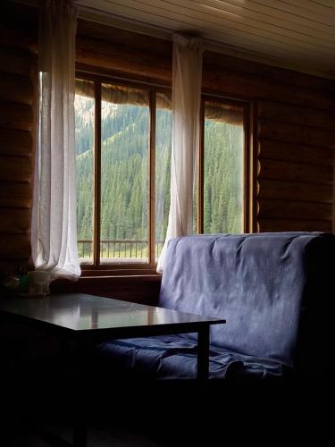 a living room with a couch and a table in front of a window at Arashan Hotel in Mineralʼnyy Istochnik Altyn-Arasan