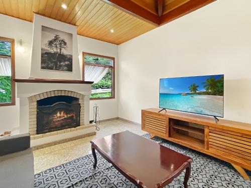 a living room with a fireplace and a flat screen tv at Capivari Lareira Harry Potter Baden Baden in Campos do Jordão