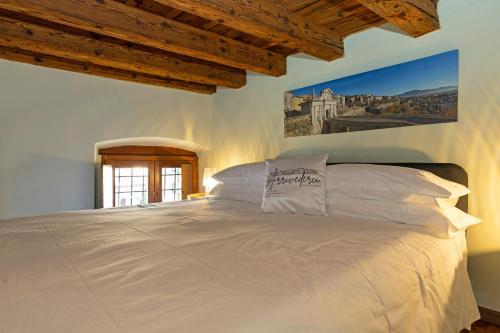 a bedroom with a large bed with white pillows at Arrivederci Apartment in Bergamo