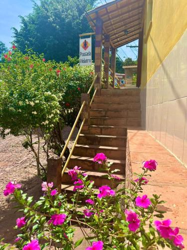 a set of stairs with pink flowers in front of a building at Pousada Violeiro in Lençóis