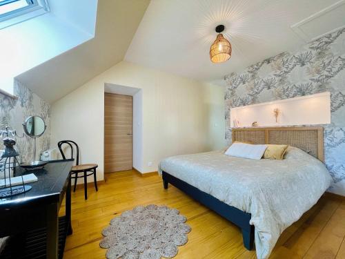 a bedroom with a bed and a desk at Les Chatons - Gite au coeur de la campagne in Fresville