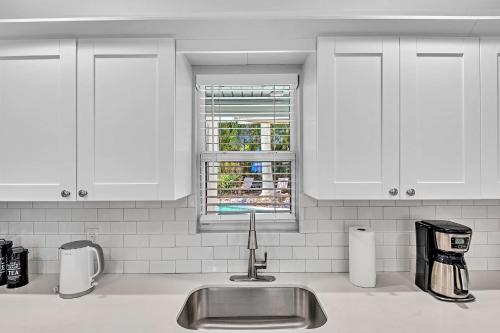 eine weiße Küche mit Spüle und Fenster in der Unterkunft Private Jungle Pool Home - Arcade Games & Pool in Fort Lauderdale