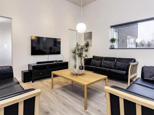 a living room with a couch and a table at 5 star holiday home in Væggerløse in Bøtø By