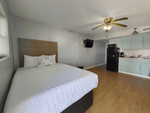アトランティックビーチにあるSand Dollar Motelのベッドと天井扇風機のある寝室