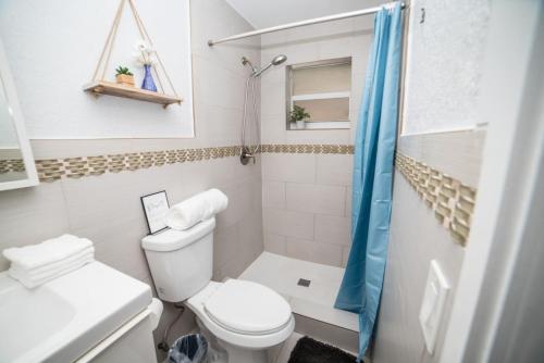 a white bathroom with a toilet and a shower at Chic MangoTree villa Private Heated Pool in Fort Lauderdale