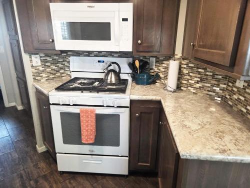 a kitchen with a stove and a microwave at Moab Rim Cabin #16 in Moab