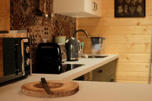 a kitchen with a wooden cutting board on a counter at Welhams Meadow Holiday Lodges in Ringshall