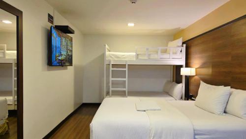 a small room with a bed and bunk beds at Hotel La Farola in Cuenca
