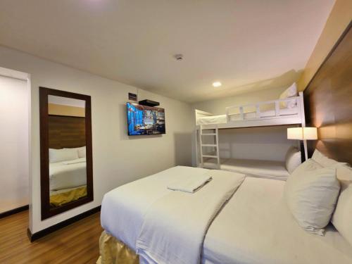 a bedroom with a large white bed and a mirror at Hotel La Farola in Cuenca