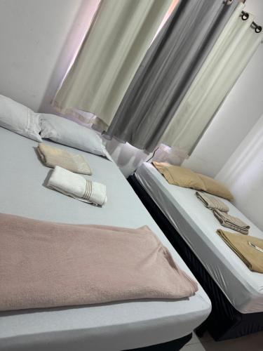 two beds sitting next to each other in a room at Casa de temporada in Trindade