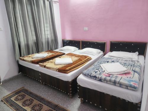 two beds sitting next to each other in a room at Hotel Namami Gange & Restaurant in Kedārnāth
