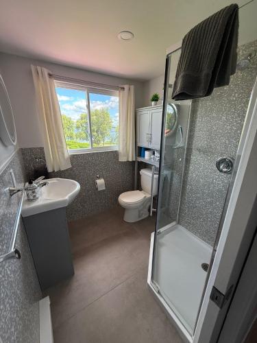 a bathroom with a shower and a toilet and a sink at Hostellerie du Suroît in Beauharnois