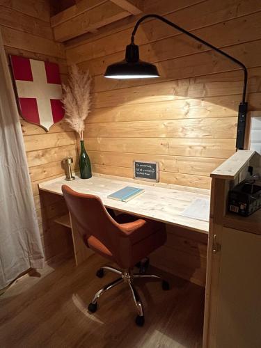 a desk with a chair and a flag on a wall at Chalet Ro'mence, aux portes de la Savoie in Nattages