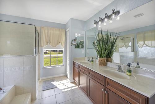 a bathroom with a sink and a mirror and a tub at Family Retreat - Sleeps 10 - Pool - Near Beach in Port Charlotte