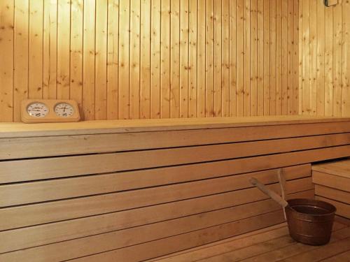 a sauna with a bucket and a clock on the wall at 8 person holiday home in Henån-By Traum in Henån