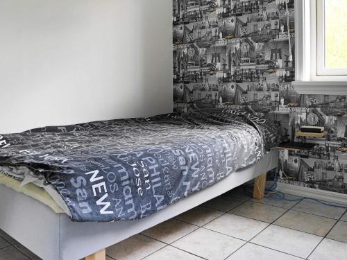 a bed in a room with a black and white wallpaper at 8 person holiday home in Henån-By Traum in Henån