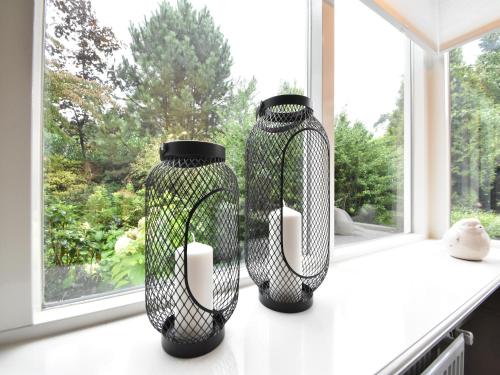 two black vases sitting on a window sill at Holiday Home in Holten near Holterberg in Holten
