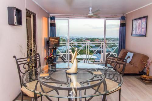 a living room with a glass table and a balcony at Cozy Accommodations - Dorchester City Line in Kingston